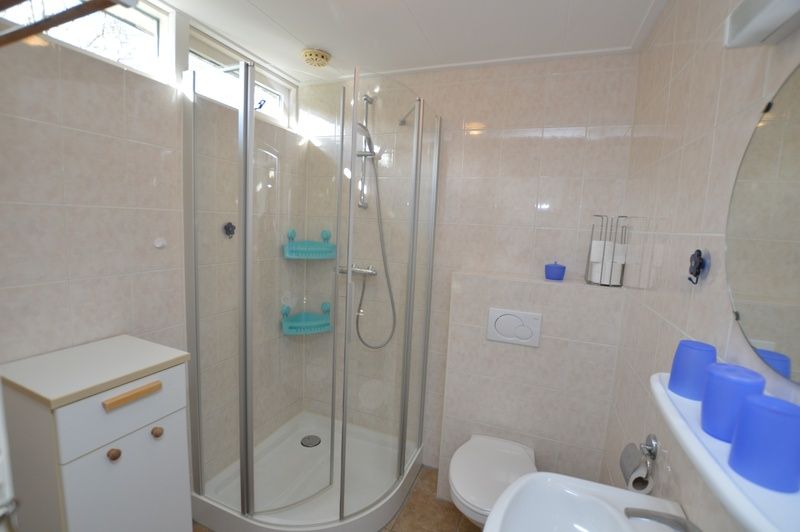 Moderne badkamer in Vakantiehuis de Parel 212, De Dennen, Texel met douchecabine.