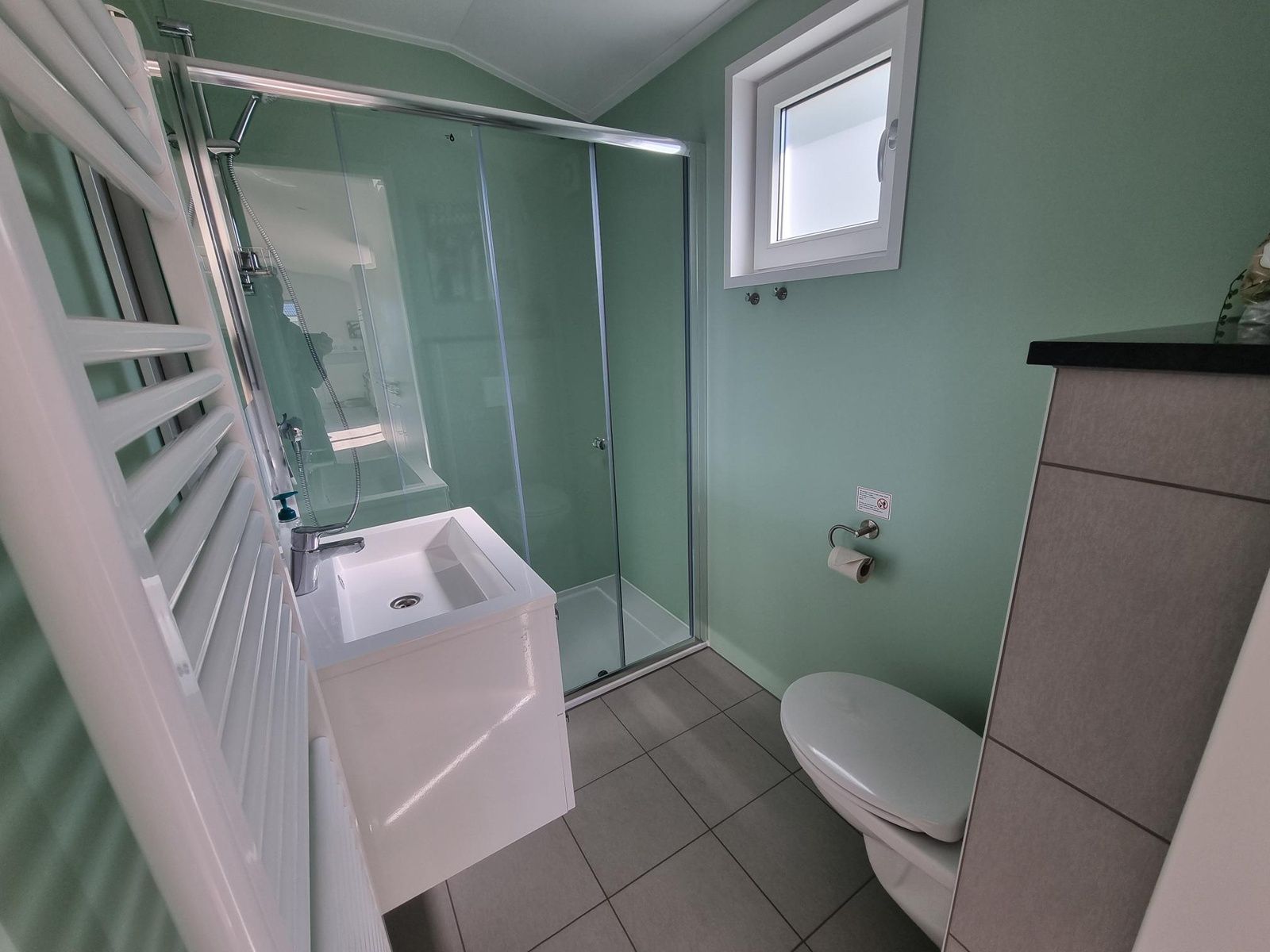 Modernes Badezimmer im Vakantiepark de Bremakker - Bosveld 135, Ferienhaus in De Dennen, Texel mit Dusche und Waschbecken.