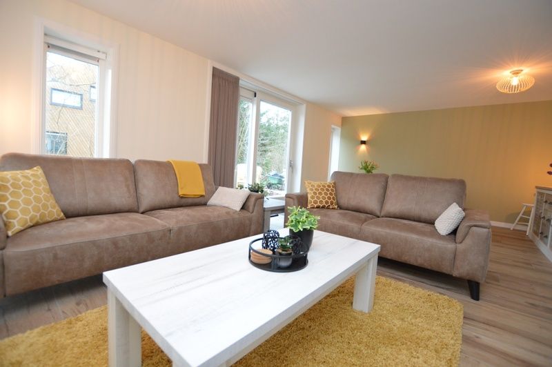 Gemuetliches Wohnzimmer des Ferienhauses De Nagtegaal 23, De Dennen, Texel, mit viel Tageslicht.