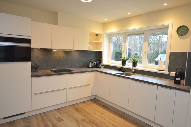 Moderne Kueche im Ferienhaus De Nagtegaal 23, De Dennen, Texel, mit Blick in die Umgebung.