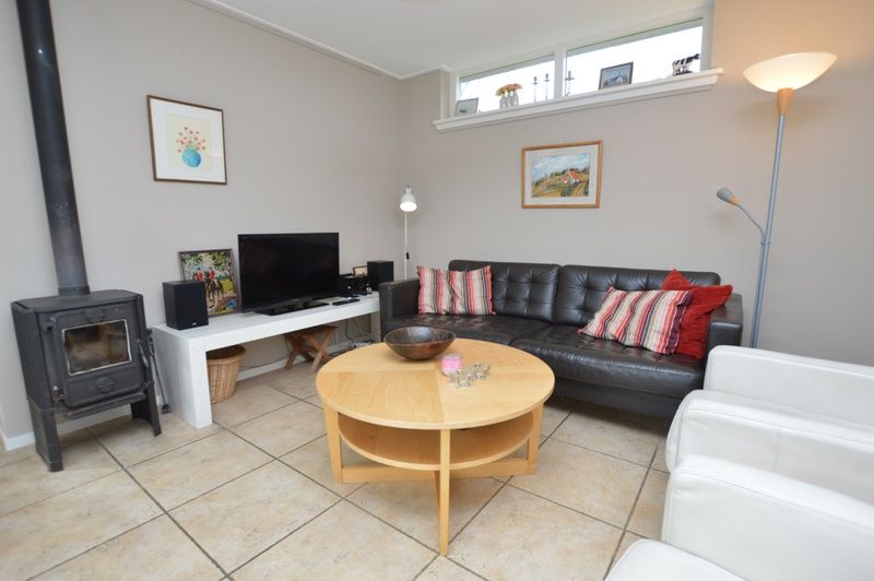 Stilvolles Wohnzimmer mit Holzofen im Bungalow Uterste Coogh 78, De Dennen, Texel.