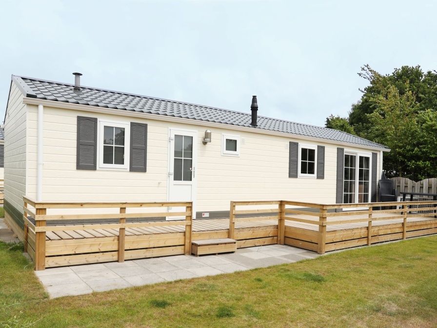 Villetta Sauna, Ferienhaus in De Dennen, Texel mit grosser Terrasse und Holzzaun.