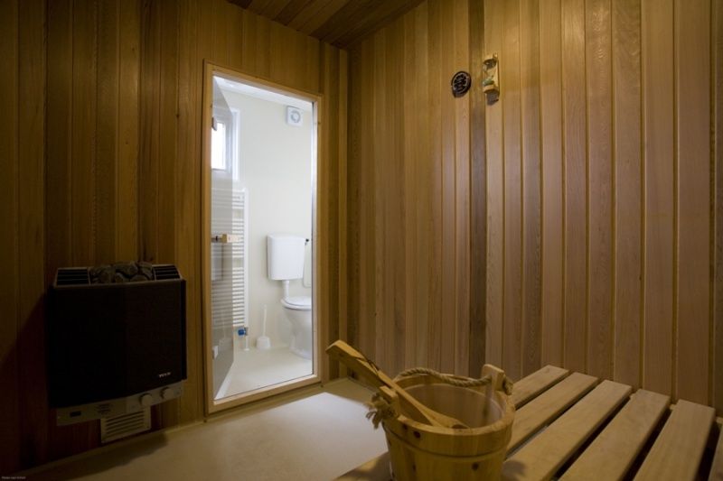 Privatsauna in Villetta Sauna, Texel, mit Holzausstattung und direktem Zugang zum Badezimmer.