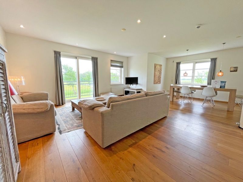 Open woonruimte van Appartement Bos en Duin 40 in De Dennen, Texel, met eetgedeelte en uitzicht op de groene omgeving.