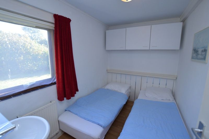 Schlafzimmer mit zwei Betten in Ferienhaus de Parel 222, De Dennen, Texel.