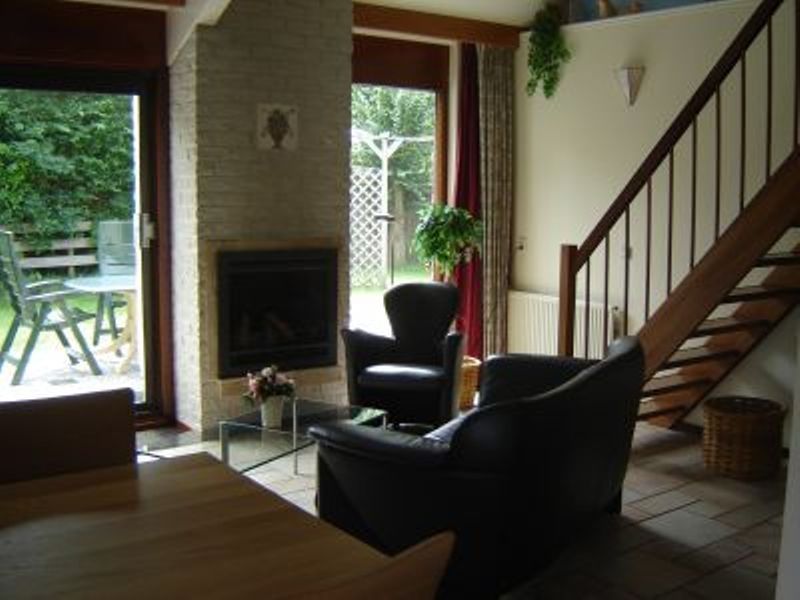 Cozy living room with fireplace in Holiday home Gortersmient 356, De Dennen, Texel. Ideal for cozy evenings on the Wadden Islands.