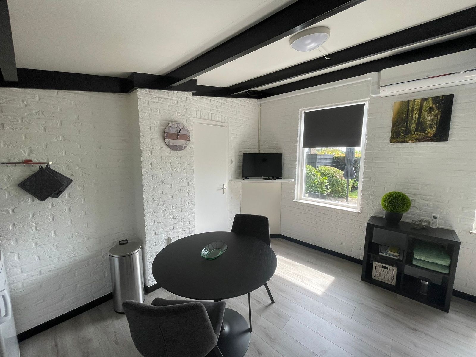 Dining area in Wollewei vacation home, De Dennen, Texel, with round table and chairs.
