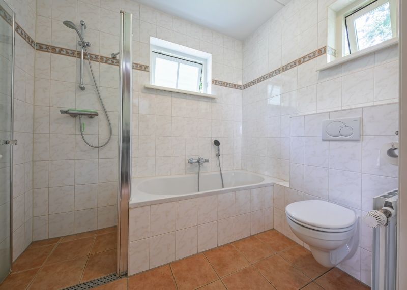 Luxury bathroom with bath and shower in 't Mienthuis - De Jonker, vacation home in De Dennen, Texel, for ultimate comfort on the Wadden Islands.