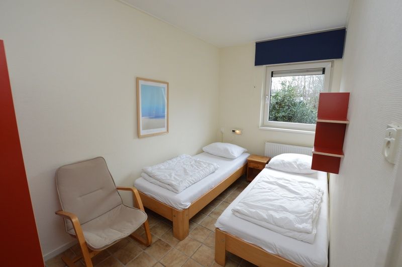 Bedroom with two single beds in Holiday home de Parel 204, De Dennen, Texel.