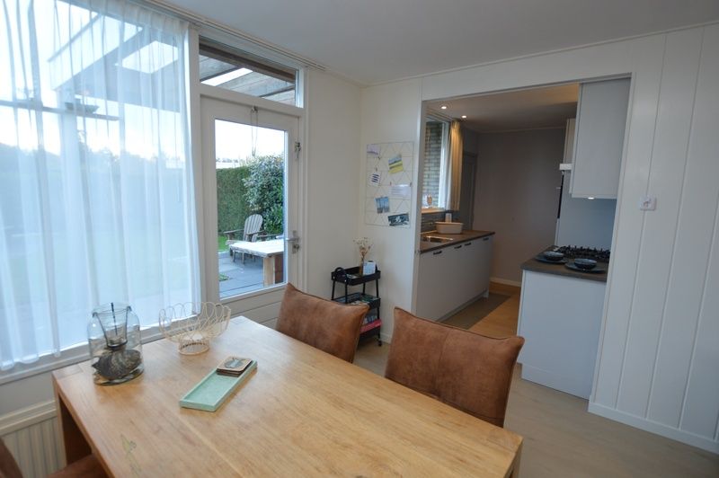 Offene Kueche und Essbereich im Ferienhaus Uterste Coogh 104, Texel, mit Zugang zur Terrasse.