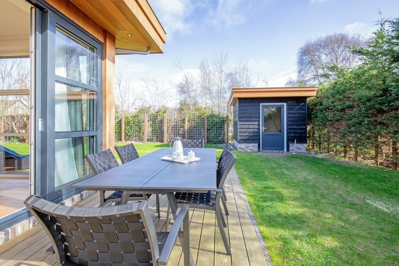 Ontspan op het buitenterras van Vakantiehuis De Vlinder in Bungalowpark 't Hoogelandt, omgeven door de natuur van De Dennen, Texel.