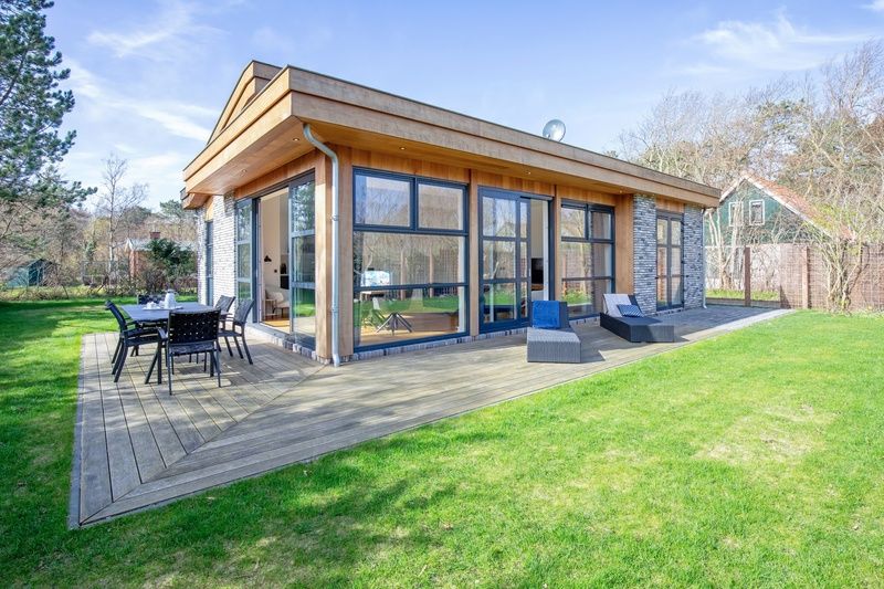 Vakantiehuis De Vlinder in Bungalowpark 't Hoogelandt op Texel biedt een ruim terras met zitgelegenheid in de natuurlijke omgeving van De Dennen.