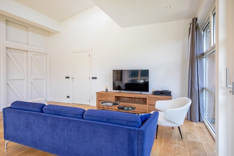 Comfortabele zithoek in Vakantiehuis De Vlinder, Bungalowpark 't Hoogelandt, Texel, met een moderne inrichting en uitzicht op De Dennen.