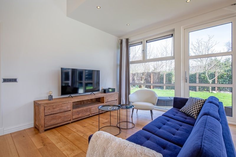Lichte woonkamer met een moderne inrichting in Vakantiehuis De Vlinder, Bungalowpark 't Hoogelandt, Texel, omgeven door de natuur van De Dennen.