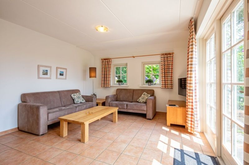 Gemuetliches Wohnzimmer von 't Mienthuis - De Prins, Ferienhaus in De Dennen, Texel, mit geraeumigen Sitzgelegenheiten und viel Licht.