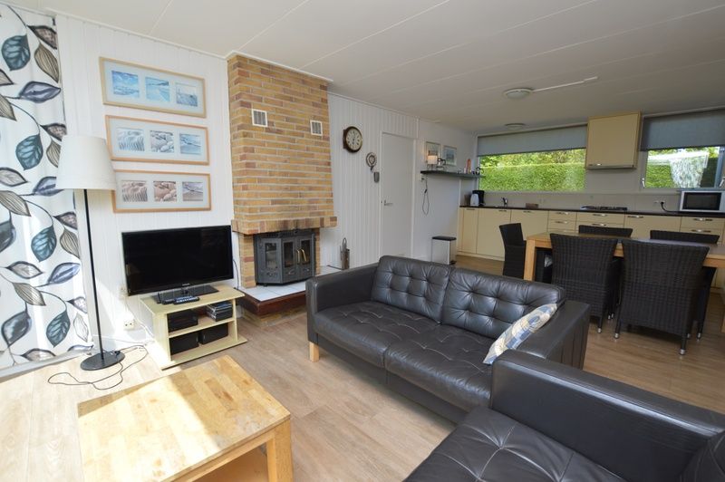 Ferienhaus de Parel 282 in De Dennen, Texel, gemuetliches Wohnzimmer mit Kamin und Essecke.