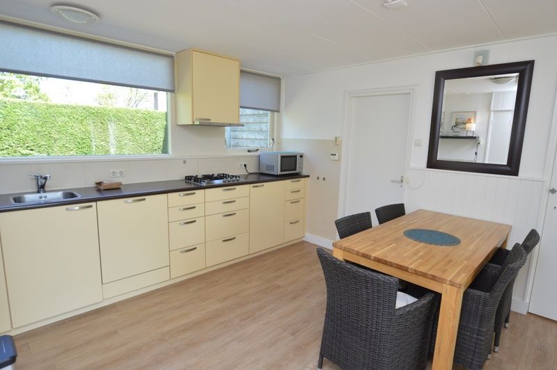 Geraeumige Kueche und Esszimmer im Ferienhaus de Parel 282, De Dennen, Texel mit Blick auf den Garten.