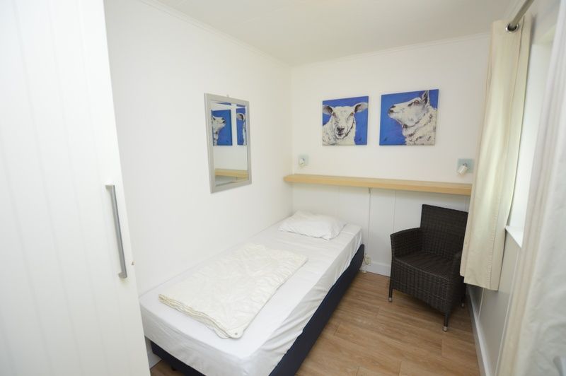 Schlafzimmer mit Kunstdekoration im Ferienhaus de Parel 282, De Dennen, Texel fuer eine entspannte Atmosphaere.