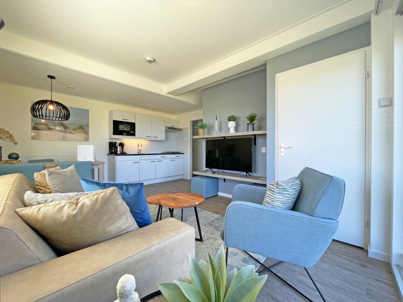 Ruime woonruimte in Appartement Bos en Duin 30, De Dennen, Texel met moderne keuken en comfortabele zithoek.
