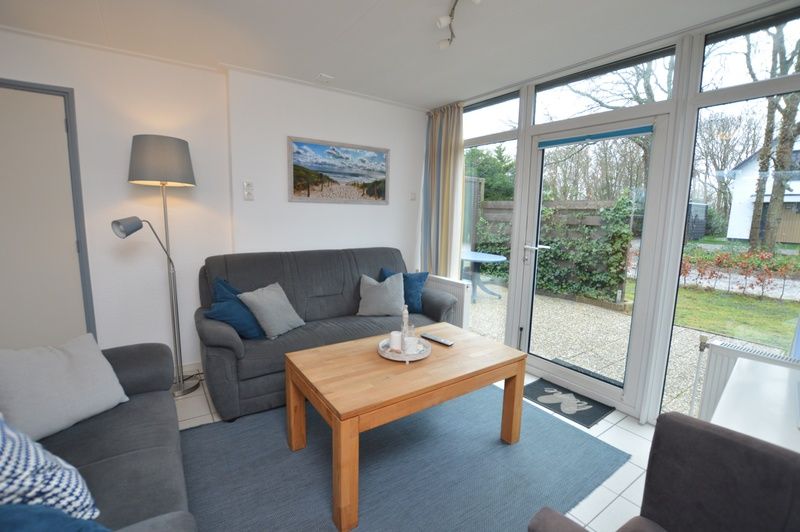 Gemuetliche Sitzecke im Holiday home de Parel 194, De Dennen, Texel mit Blick auf den Garten.
