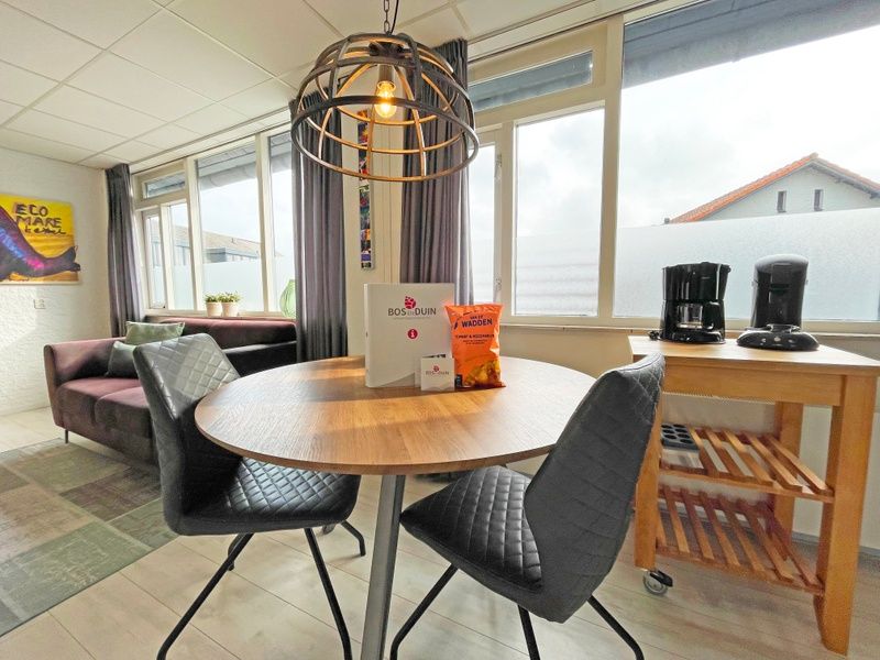 Essecke am Fenster im Apartment Bos en Duin 25, De Dennen, Texel mit Blick auf die Umgebung.