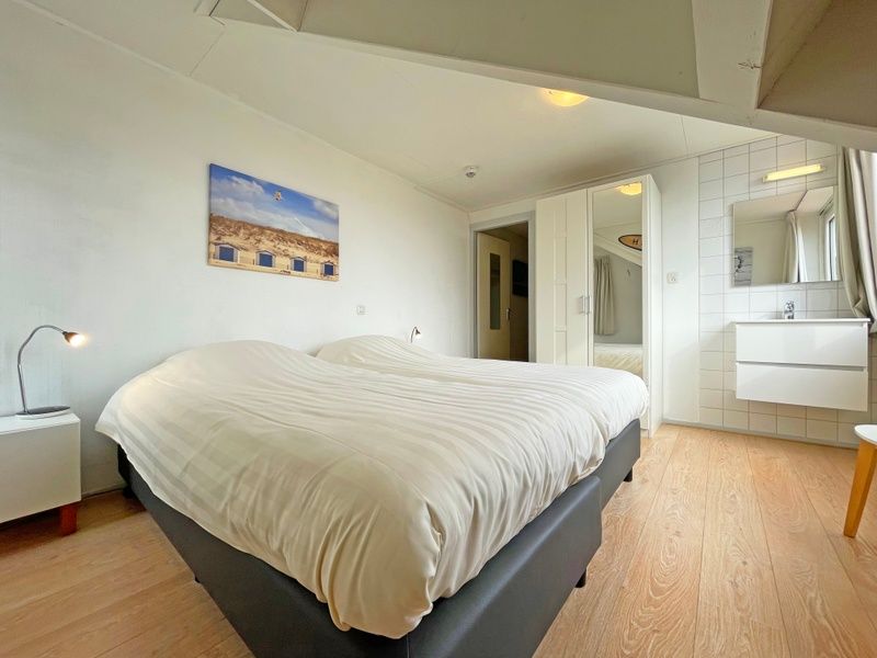 Geraeumiges Schlafzimmer im Appartement Bos en Duin 25, De Dennen, Texel mit bequemem Doppelbett.