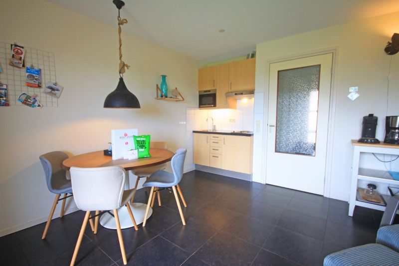 Open keuken in Appartement Bos en Duin 42, De Dennen, Texel met eethoek en praktische voorzieningen.