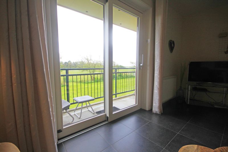 Balkon van Appartement Bos en Duin 42, Texel met prachtig uitzicht op de natuur van De Dennen.