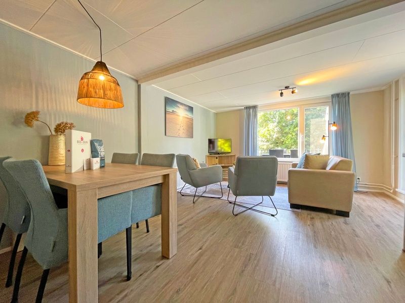 Spacious sitting area in Apartment Bos en Duin 22, De Dennen, Texel overlooking the green surroundings.