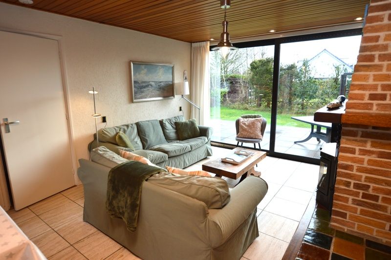 Cozy living room in Holiday home de Parel 258, Texel, overlooking the garden.