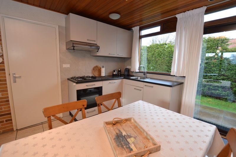 Cozy dining area in Holiday home de Parel 258, Texel, with access to the garden.