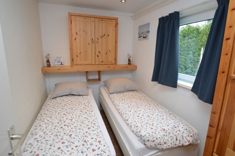 Bedroom with two single beds in Holiday home de Parel 258, Texel.
