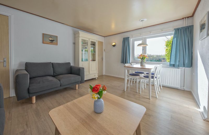 Gemuetliches Wohnzimmer des Ferienhauses Swalefie in De Dennen, Texel mit Blick auf die Natur.