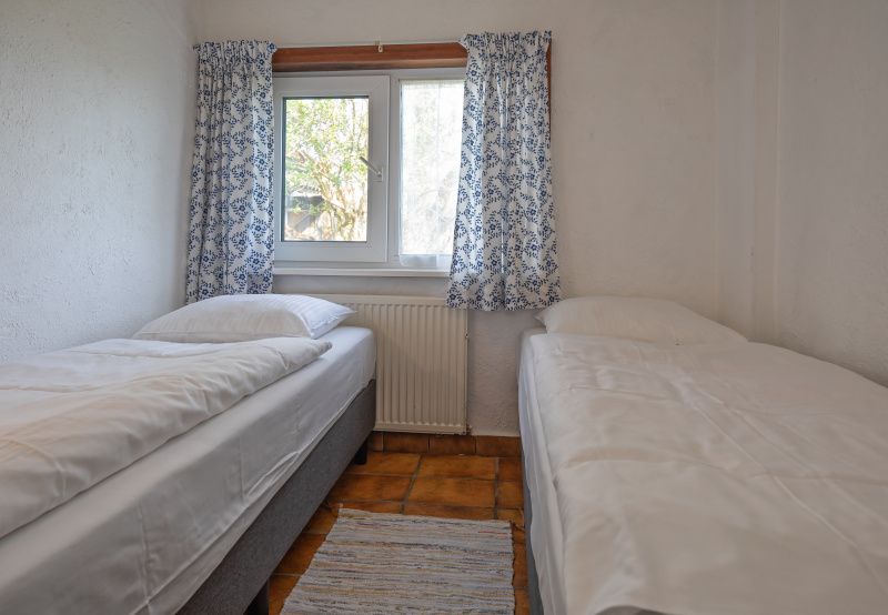 Schlafzimmer mit zwei Einzelbetten im Ferienhaus Duumpie, De Dennen, Texel.