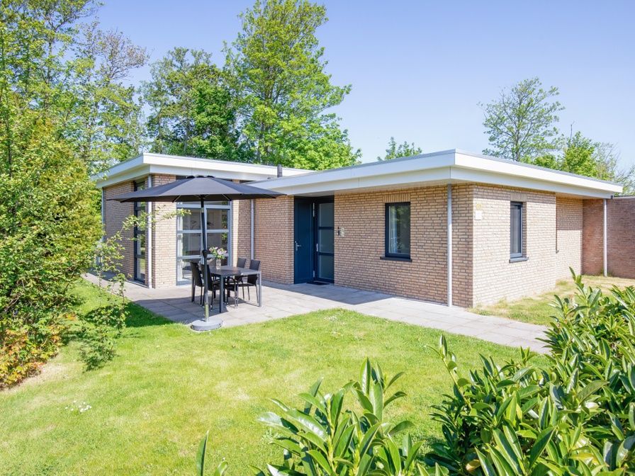 Bungalowpark Verste Coogh - Hermelijn in De Dennen, Texel mit sonniger Terrasse und gruener Umgebung.