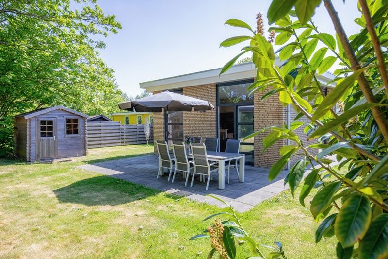 Bungalowpark Verste Coogh - Hermelijn, Texel: Geraeumige Terrasse mit Sitzgelegenheiten in gruener Umgebung.