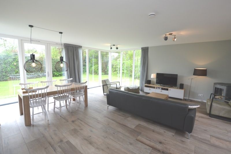 Bright living room of Tempelierweg 16 - de Brunaire, vacation home in De Dennen, Texel overlooking green garden.