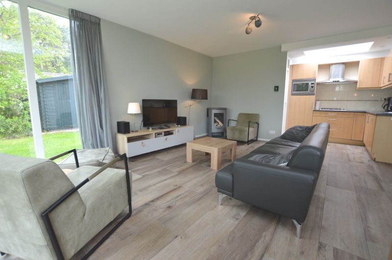 Comfortable sitting area in Tempelierweg 16 - de Brunaire, Texel, with modern furnishings and large windows.