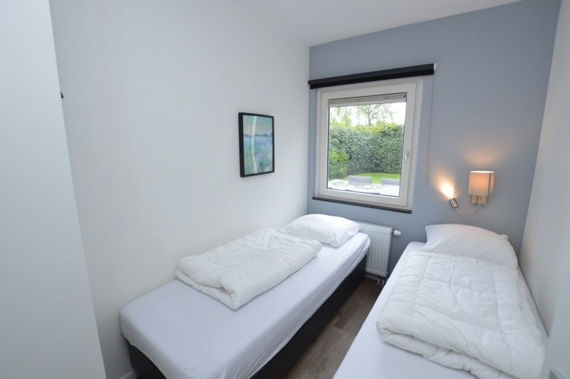 Bedroom with two single beds in Tempelierweg 16 - de Brunaire, Texel, ideal for families.