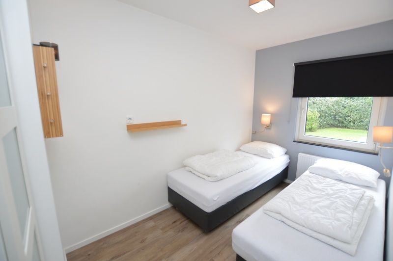 Second bedroom in Tempelierweg 16 - de Brunaire, Texel with comfortable bed and garden view.