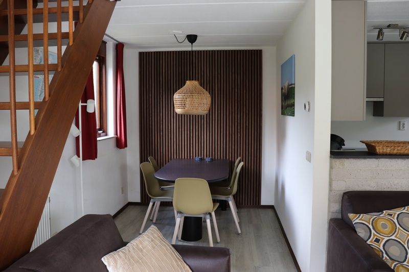 Gezellige eethoek in Vakantiehuis Gortersmient 216, De Dennen, Texel met houten tafel en stoelen.