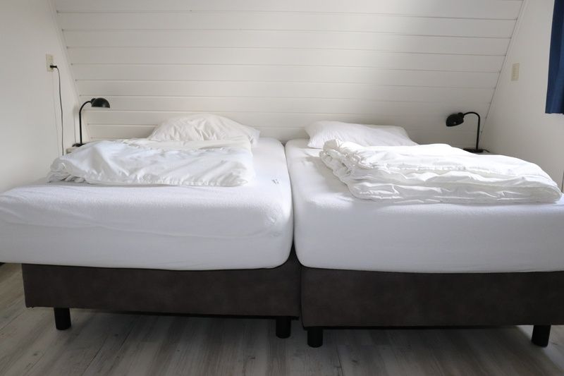 Slaapkamer met twee bedden in Vakantiehuis Gortersmient 216, De Dennen, Texel voor een goede nachtrust.