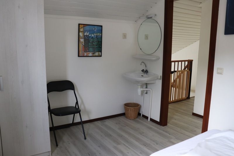 Slaapkamerdetail in Vakantiehuis Gortersmient 216, De Dennen, Texel met wastafel en moderne inrichting.