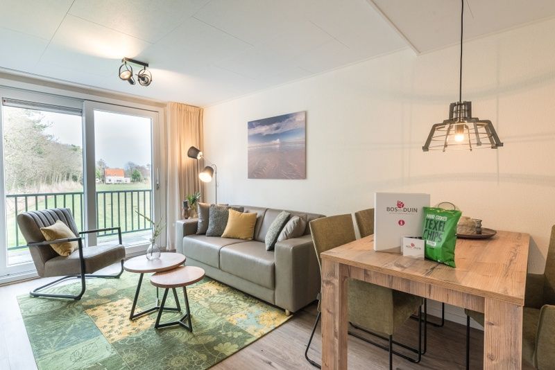 Moderne Sitzecke im Appartement Bos en Duin 32, De Dennen, Texel mit Blick auf die Natur.