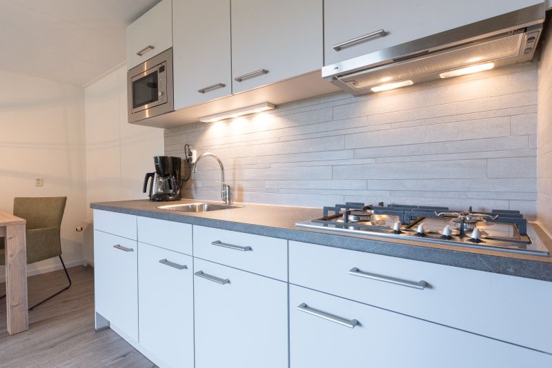 Vollstaendig ausgestattete Kueche des Appartements Bos en Duin 32, De Dennen, Texel mit modernen Geraeten.