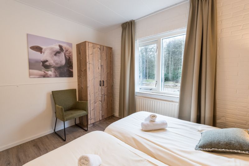 Schlafzimmer mit Doppelbett im Appartement Bos en Duin 32, De Dennen, Texel mit Tageslicht.