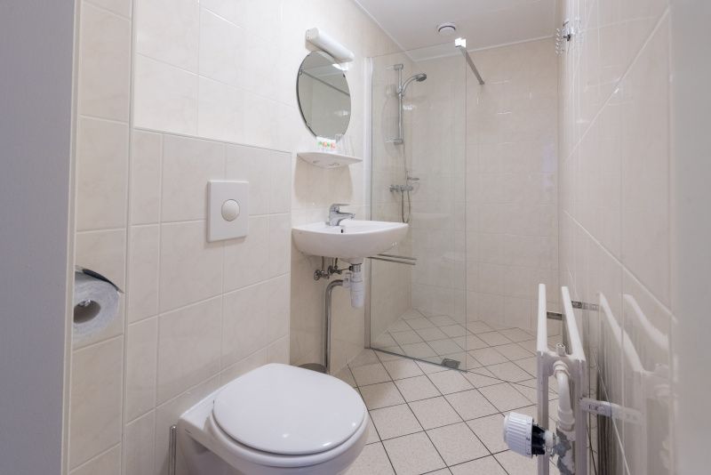 Modernes Badezimmer im Apartment Bos en Duin 32, De Dennen, Texel mit Dusche und Waschbecken.