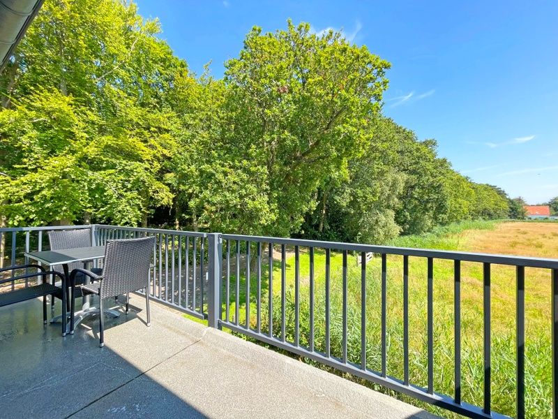 Geraeumige Terrasse des Appartements Bos en Duin 32, De Dennen, Texel, umgeben von viel Gruen.