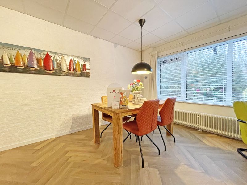 Dining area with artwork in Apartment Bos en Duin 04, De Dennen, Texel, ideal for cozy meals.