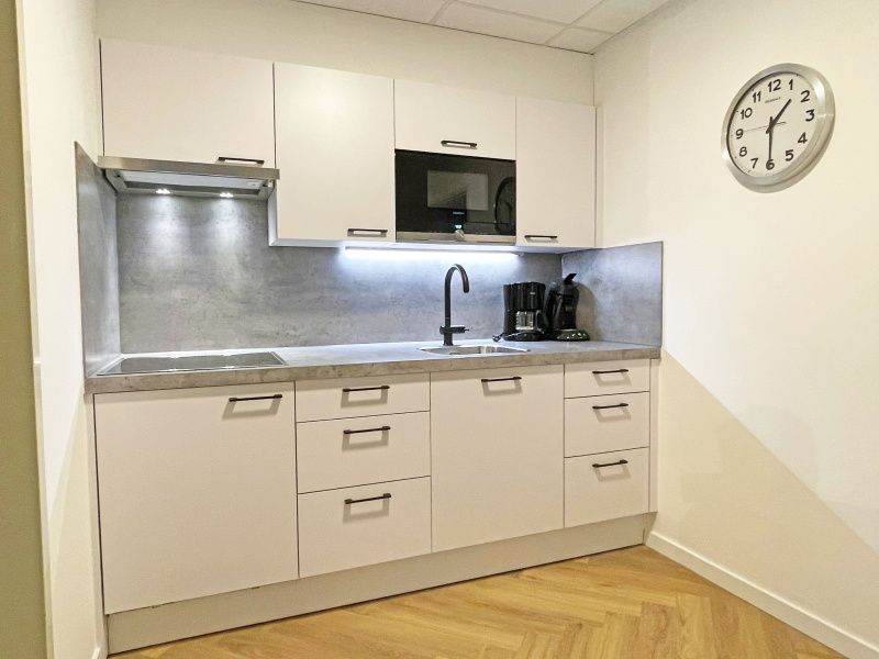 Modern kitchen in Apartment Bos en Duin 04, De Dennen, Texel with sleek white cabinets and built-in appliances.